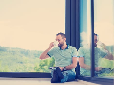 Real man Using tablet on the floor At Home Drinking Coffee Enjoying Relaxing