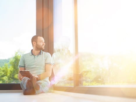 Real man Using tablet on the floor At Home Drinking Coffee Enjoying Relaxing