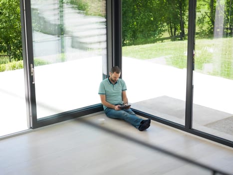 Real man Using tablet on the floor At Home Drinking Coffee Enjoying Relaxing