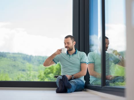 Real man Using tablet on the floor At Home Drinking Coffee Enjoying Relaxing