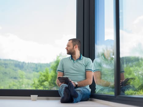 Real man Using tablet on the floor At Home Drinking Coffee Enjoying Relaxing