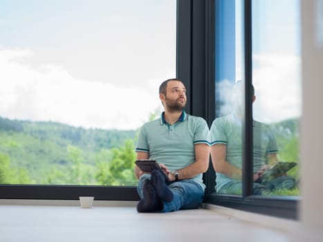 Real man Using tablet on the floor At Home Drinking Coffee Enjoying Relaxing