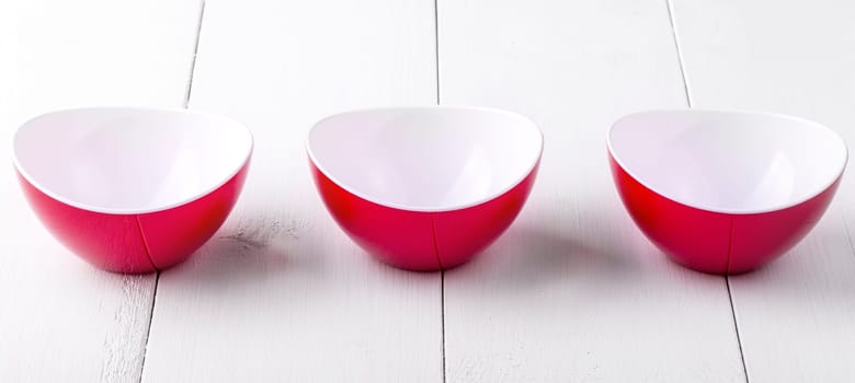 An three empty red cups on a white wooden table