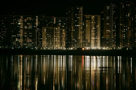 skyscrapers reflected in water at night panorama down up