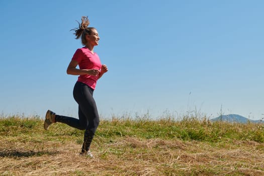 woman  jogging in a healthy lifestyle on a fresh mountain air at beautiful sunny summer nature