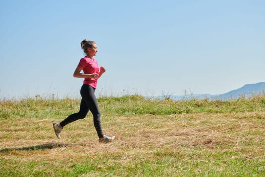 woman  jogging in a healthy lifestyle on a fresh mountain air at beautiful sunny summer nature