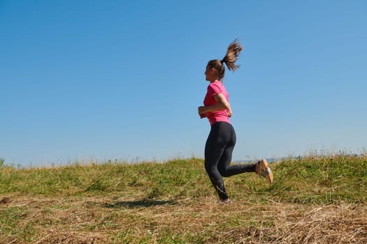 woman  jogging in a healthy lifestyle on a fresh mountain air at beautiful sunny summer nature