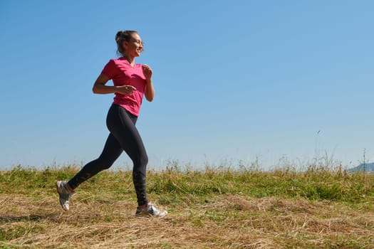 woman  jogging in a healthy lifestyle on a fresh mountain air at beautiful sunny summer nature