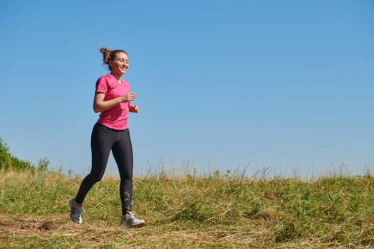 woman  jogging in a healthy lifestyle on a fresh mountain air at beautiful sunny summer nature