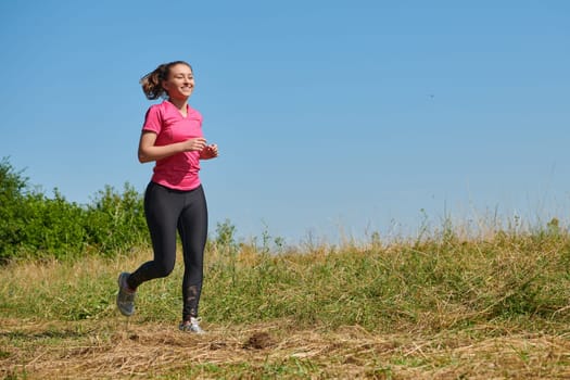 woman  jogging in a healthy lifestyle on a fresh mountain air at beautiful sunny summer nature