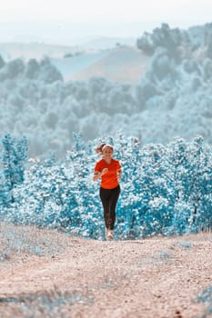 woman enjoying in a healthy lifestyle while jogging on a country road through the beautiful sunny forest, exercise and fitness concept