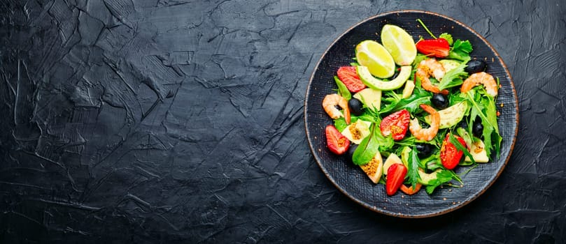 Diet salad with shrimps,strawberries and avocado.Salad in a stylish metal plate