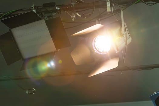 Professional orange studio spotlight hanging on the ceiling.