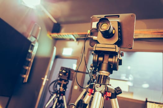 Film camera on a tripod in a television broadcasting studio, spotlights and equipment