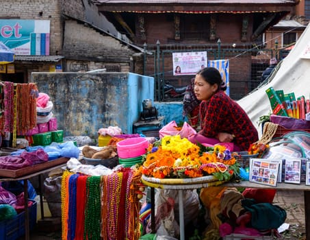 KATHMANDU, NEPAL - FEBRUARY 16, 2015: Woman selling flowers and other items at Pashupatinath.