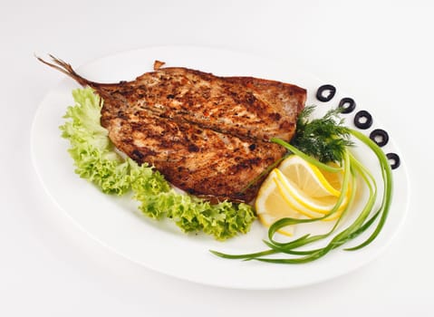 roast fish with lemon, onion and olives,lemon isolated
