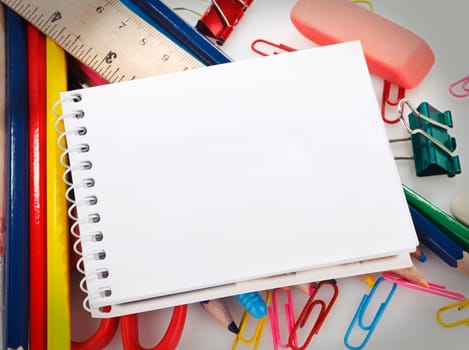 office supplies and notebook with blank sheet