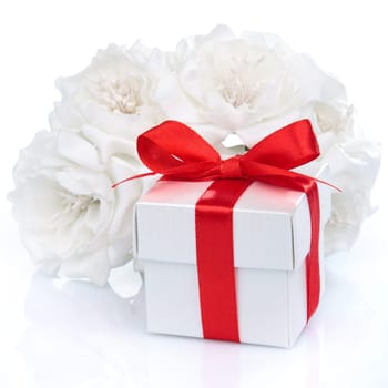 white gift box with red ribbon, bow and flowers on a white background