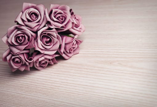 purple flowers on wooden surface with place for text