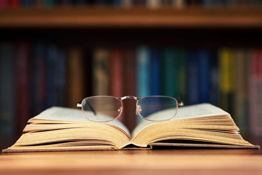 glasses and book on background bookcase