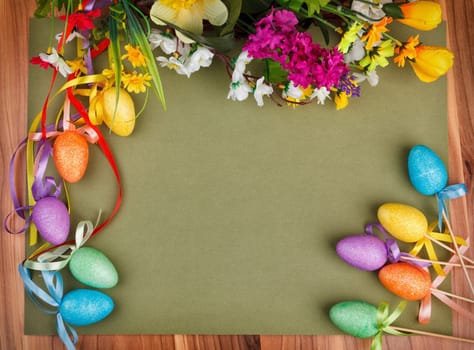 Easter flower arrangement and colorful eggs on green background with space for text