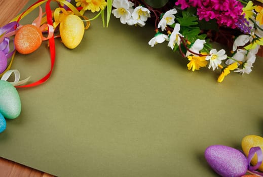 Easter flower arrangement and colorful eggs on green background with space for text