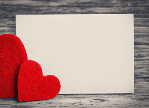 greeting card with a red hearts and space for text on a wooden background