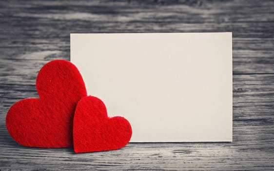 greeting card with a red hearts and space for text on a wooden background