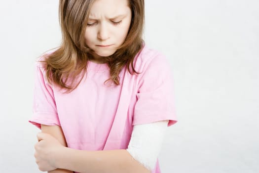 The sad girl with a bandage on his hand. Injury limbs child