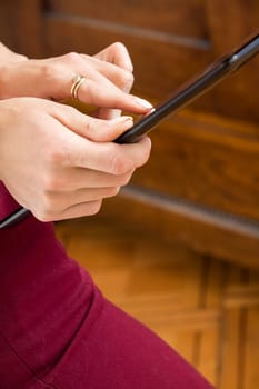 Successful red-haired woman studied undergraduate with tablet in the office at the desk