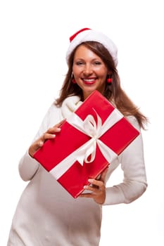 Pretty brunette woman with Christmas hat and big red gift cheerfullaughing isolated against white background