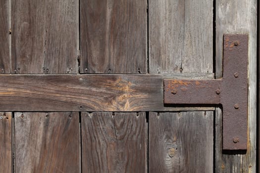 Old weathered wooden door reinforced with iron