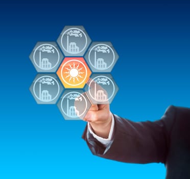 Hand of a business person activating a solar power icon by touch. The solar energy button is flashing yellow at the center of interface keys depicting grey factory symbols. Metaphor for energy turn.