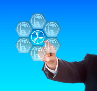 Electric power generation through wind energy. Arm of a business manager activating a wind turbine symbol on a touch screen interface. Metaphor for energy transition, the so called Energiewende.