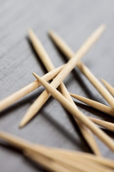 Stack of wooden toothpicks as close-up macro detail on dark background