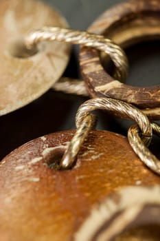 Bracelet or necklace with copper colored round pendants as close-up on dark background