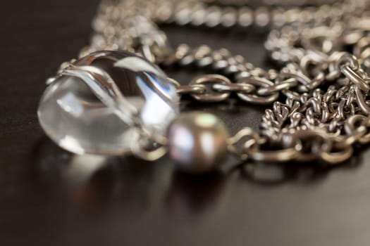 Silver jewels chains necklaces Armbanfmit Petrlen shiny on dark background