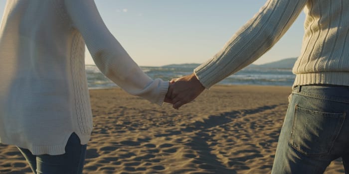 Romantic Couple Relaxing On The Beach during autumn day