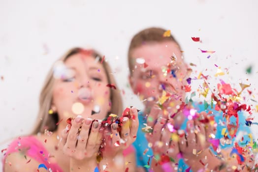 young romantic  couple in love  celebrating and blowing confetti decorations