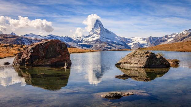 Famous alpine peak Matterhorn reflected in a pond in the Swiss Alps