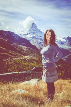 Young woman enjoying a view in the mountains near Swiss resort town of Zermatt