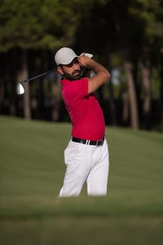 golf player shot ball from sand bunker at course