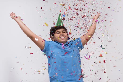 Happy kid celebrating party with blowing confetti