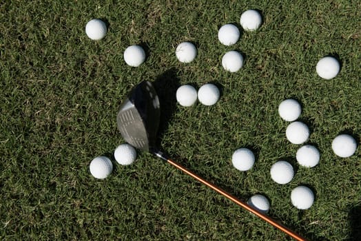 top view flat lay of golf balls with driver on grass background