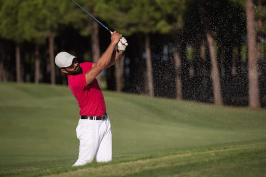 golf player shot ball from sand bunker at course