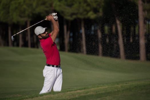 golf player shot ball from sand bunker at course