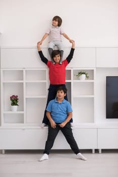 happy young boys having fun and posing line up piggyback in new modern home