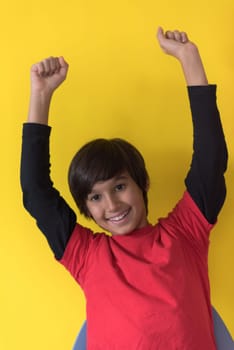 Portrait of a happy young boy in front of colored background