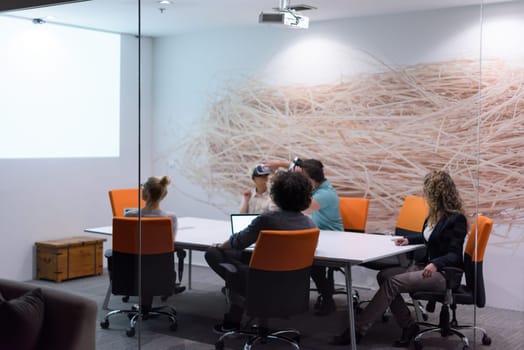 startup Business team using virtual reality headset in night office meeting  Developers meeting with virtual reality simulator around table in creative office.