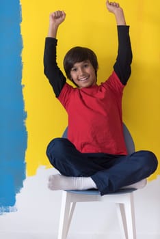 Portrait of a happy young boy in front of colored background